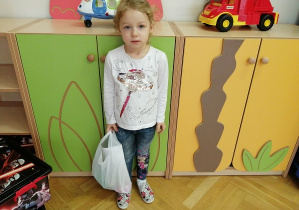 dziewczynka trzyma torbę z prezentem